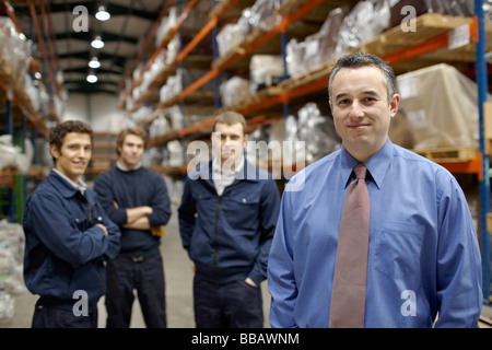 Manager and workers in warehouse Stock Photo