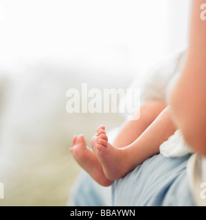 Baby feet on mother's lap Stock Photo