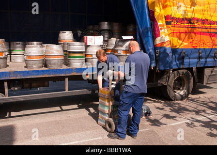 Two  Adnams brewery staff workers unloading and delivering ale and beer to a pub from the back of a lorry in Suffolk,Uk Stock Photo