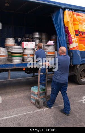 Two  Adnams brewery staff workers unloading and delivering ale and beer to a pub from the back of a lorry in Suffolk,Uk Stock Photo