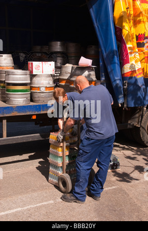 Two  Adnams brewery staff workers unloading and delivering ale and beer to a pub from the back of a lorry in Suffolk,Uk Stock Photo