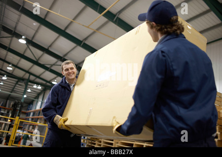 Two workers carrying large box Stock Photo