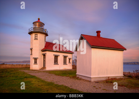 Vashon Island WA Point Robinson lighthouse on Puget Sound with sunset colored sky Stock Photo