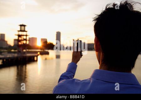 Back view of young man with mobile phone Stock Photo