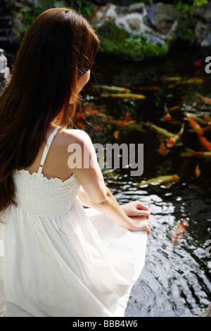 woman in white dress sitting on a bar counter Stock Photo - Alamy
