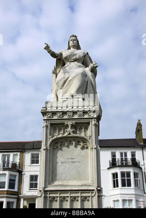 Statue of Queen Victoria pointing out to sea on Southend seafront with Victorian terraced houses in the background Stock Photo