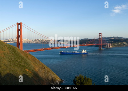 California Container ship passing under Golden Gate Bridge view of Golden Gate Bridge and city from Marin Headlands Stock Photo