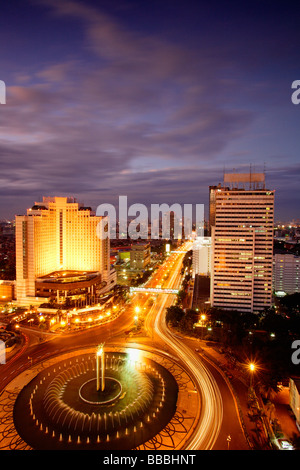 Early evening view of the Hotel Indonesia roundabout, Welcome monument and buildings along Jalan Thamrin, Jakarta Stock Photo