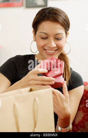 Young Woman opening gift box and smiling Stock Photo