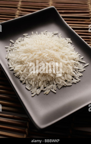 grains of uncooked rice on a square dish Stock Photo