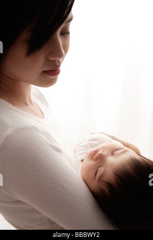 Woman holding sleeping baby Stock Photo