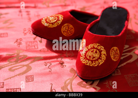 Still life of pair of red shoes on oriental design fabric Stock Photo