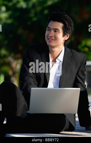 A man uses his laptop in the park Stock Photo