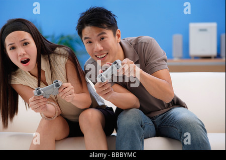 Chinese Boyfriend And Girlfriend Playing Video Games Sitting At