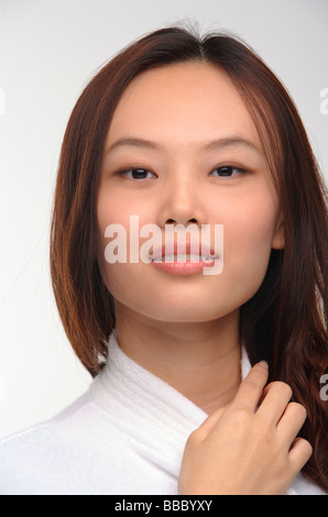 Young woman in bathrobe smiling at camera Stock Photo