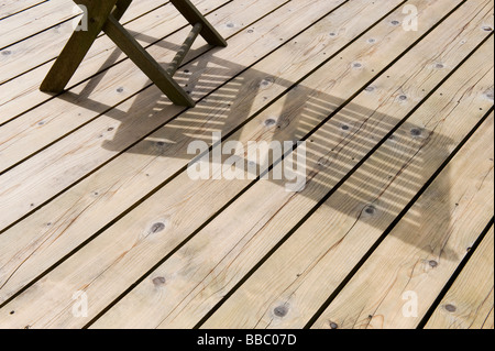 shadow of chair on new timber decking in garden Stock Photo