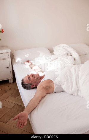 man lying on bed relaxing Stock Photo
