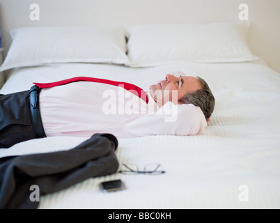 Man lying on bed looking upwards Stock Photo