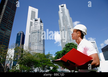 A man with a helmet stands in front of skyscrapers Stock Photo
