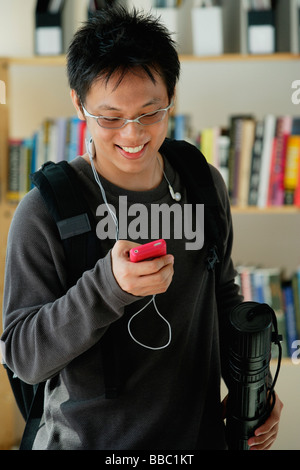 A young man listens to music in the library Stock Photo