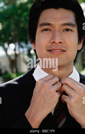 A man adjusts his tie Stock Photo