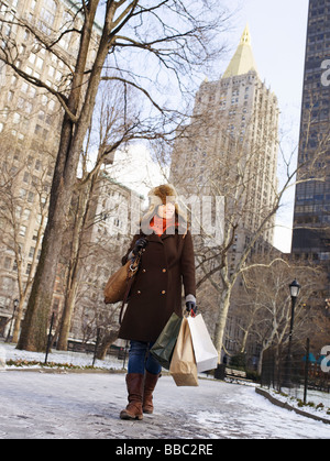 Woman with shopping in park in New York Stock Photo