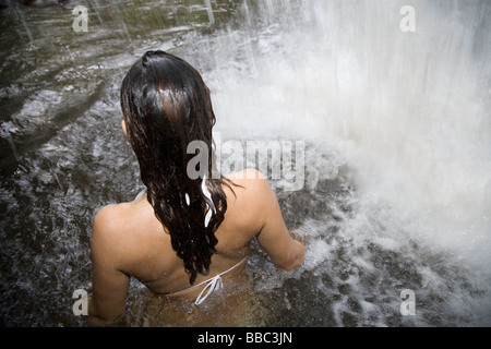 Woman Standing under Waterfall Stock Photo