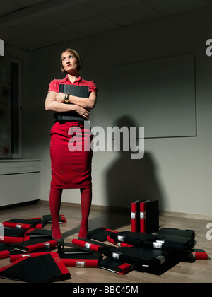 Woman standing in pile of binders Stock Photo