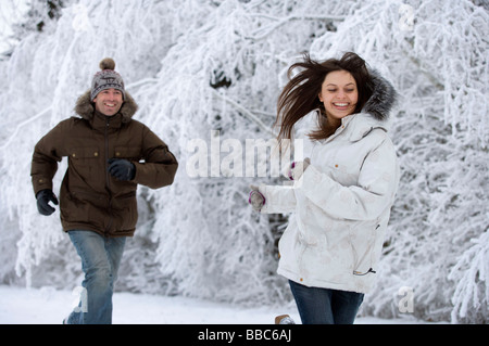 Couple running in the snow. Stock Photo