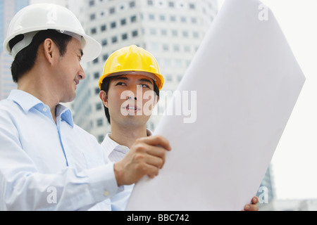 Two businessmen with blueprints Stock Photo