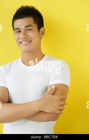 Man smiling at camera, arms crossed Stock Photo