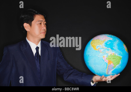 Businessman holding globe Stock Photo