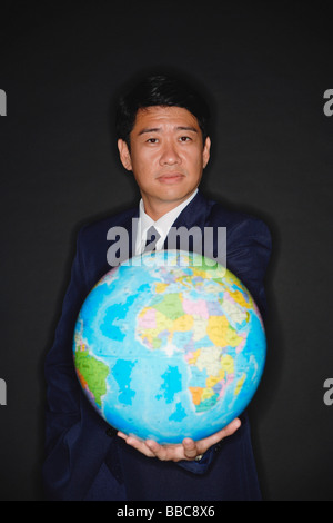 Businessman holding globe Stock Photo