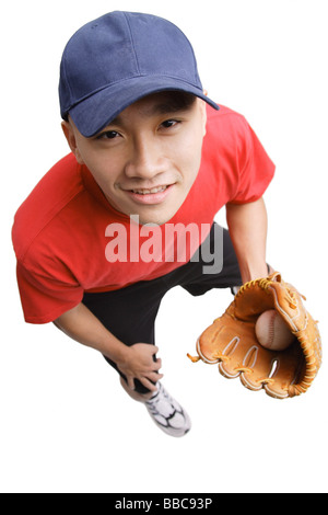 Young man wearing baseball glove and holding ball, high angle view Stock Photo