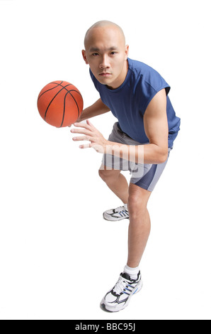 Young man holding basketball, preparing to shoot Stock Photo