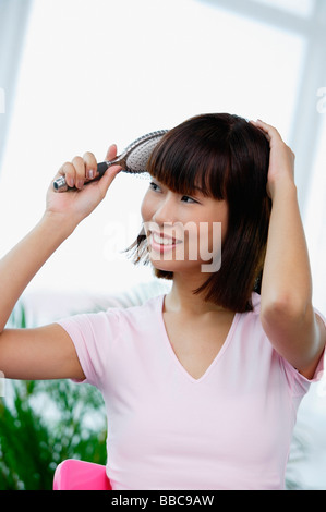 Young woman brushing her hair Stock Photo