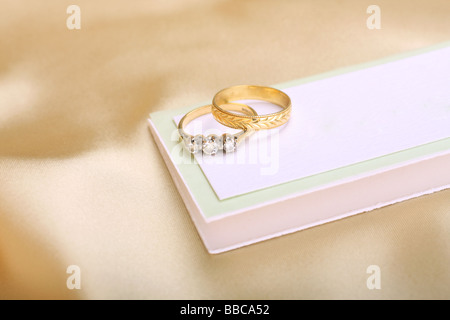 gold wedding and diamond engagement ring on blank a wedding card Stock Photo