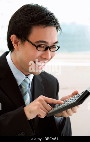 Businessman using calculator, smiling Stock Photo
