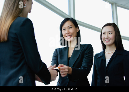 Three businesswomen exchanging business cards Stock Photo