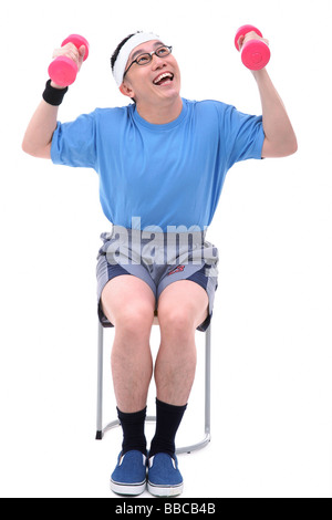 Man sitting on stool, lifting dumbbells Stock Photo
