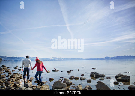 Couple walking on rocks near lake Stock Photo
