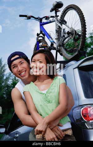 Couple standing next to SUV, portrait Stock Photo