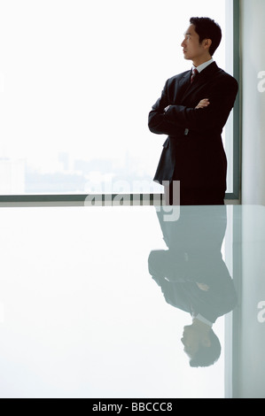 Businessman standing with arms crossed in front of railing Stock Photo ...