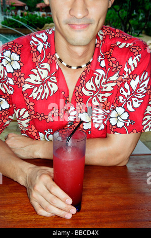 Man sitting at bar counter, holding drink Stock Photo