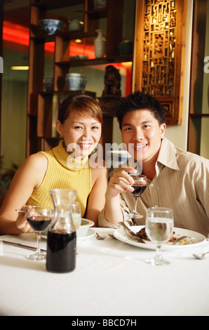 Couple having dinner in Chinese restaurant, smiling at camera Stock Photo