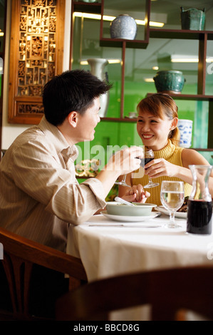 Couple toasting with wine glasses in restaurant Stock Photo