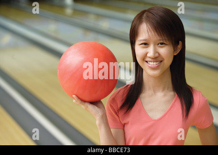 Woman at bowling alley with red bowling ball Stock Photo