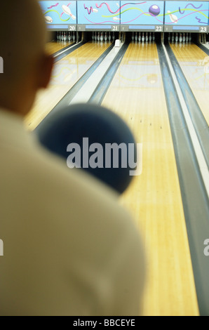 Man bowling, over the shoulder view Stock Photo