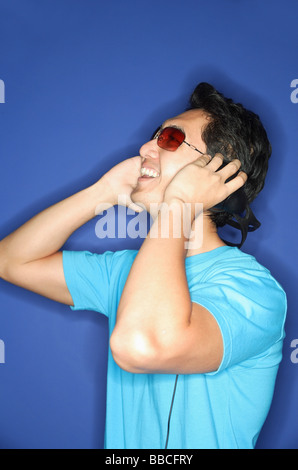 Man wearing sunglasses, wearing headphones, looking away Stock Photo