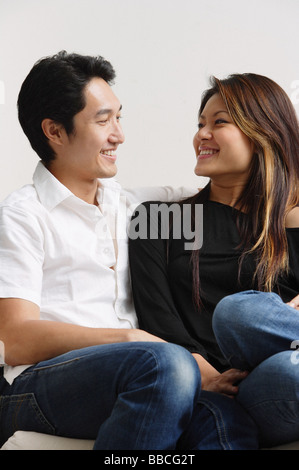 Couple sitting, smiling at each other Stock Photo